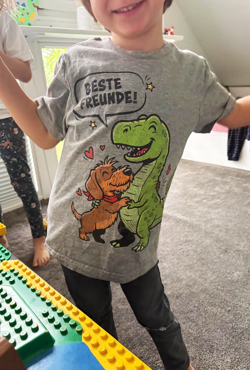 Graues Kinder-T-Shirt mit Dackel und Dino Motiv, „Beste Freunde!“ Spruch, nachhaltig – einzigartigbunt